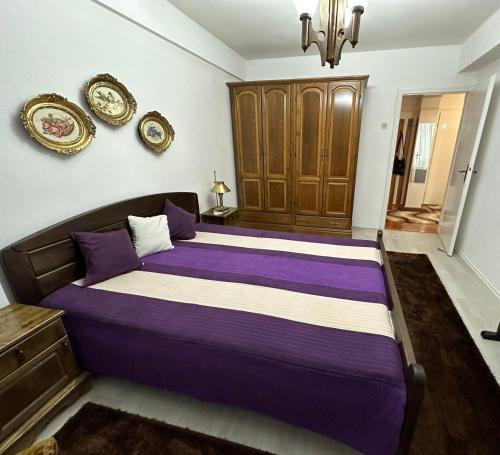 普里耶多尔Apartman MiAnaMo的一间卧室配有一张带紫色床单的大床