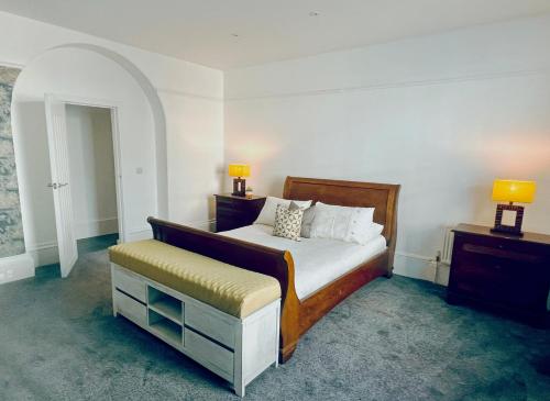 埃克塞特Perfectly located City Centre apartments的一间卧室配有一张床、一个凳子和两盏灯。