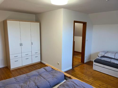 希察克尔Ferienwohnung Am Langenberg的一间卧室配有一张床、一个衣柜和床架