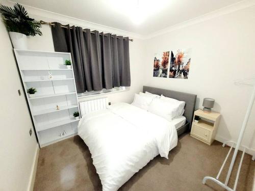 West Byfleet2 BEDROOM APT WITH 2 COMFORTABLE KING SIZE BEDs, FREE PRIVATE PARKING, EASY ACCESS TO LONDON的卧室配有白色的床和窗户。
