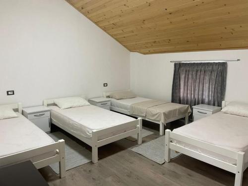 DragobiGuest house的客房设有三张床和木制天花板。