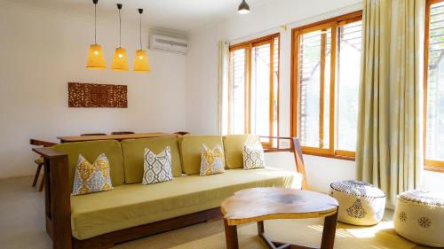 MaziziniThe Cliff 2 Bedroom Beach Apartment的客厅配有黄色的沙发和桌子