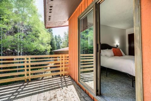 西黄石Geyser Getaway的玻璃门通向阳台的卧室,卧室配有一张床