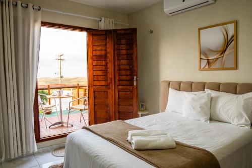 Serra de São BentoLoft vista da serra的一间卧室设有一张床,享有阳台的景色