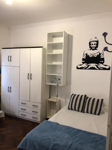 蒙得维的亚Departamento Pocitos con anfitrión的一间卧室配有一张床和一个带冥想的橱柜