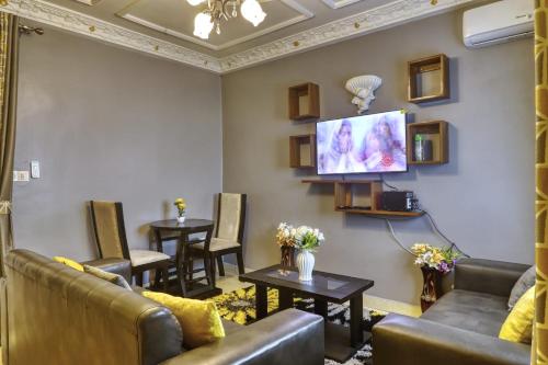 杜阿拉Meuble Modon Nyalla的带沙发和桌子以及平面电视的等候室