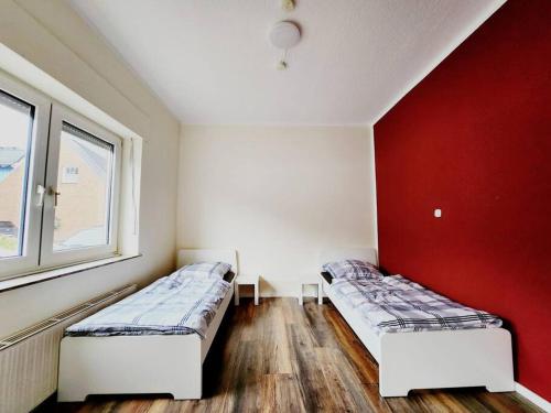 博霍尔特RNB-Appartments的红色墙壁的客房内的两张床