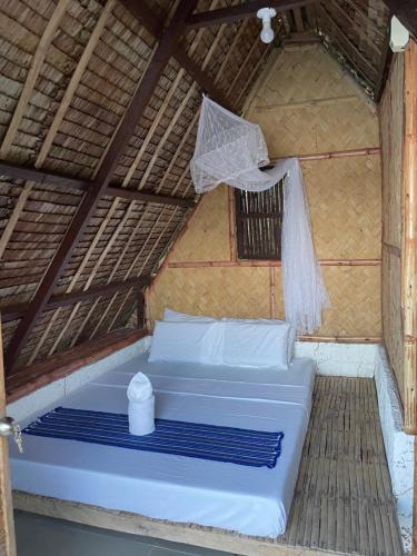 BoracBorac Bay View的稻草小屋的一张床位,带蚊帐