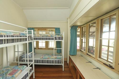 Church PointYHA Pittwater Eco, Sydney的客房设有两张双层床和一扇窗户。