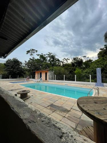 圣路易斯-杜帕赖廷加Chácara Recreio São Luiz do Paraitinga的游泳池前面设有桌子