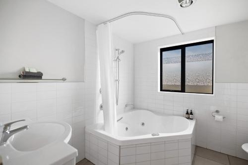 亚历山德拉Avenue Motel的白色的浴室设有浴缸和水槽。