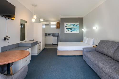 麦夸里港阿罗哈港口汽车旅馆的酒店客房,配有床和沙发
