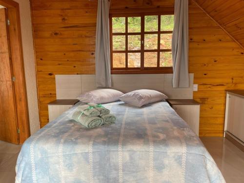 乌鲁比西Pousada Recanto das Cachoeiras的一间卧室配有带两个枕头的床和窗户