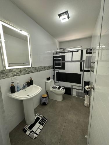 瓜亚马Black Pearl的一间带水槽、卫生间和镜子的浴室