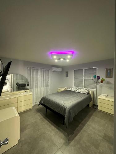 瓜亚马Black Pearl的一间卧室配有一张床和紫色灯
