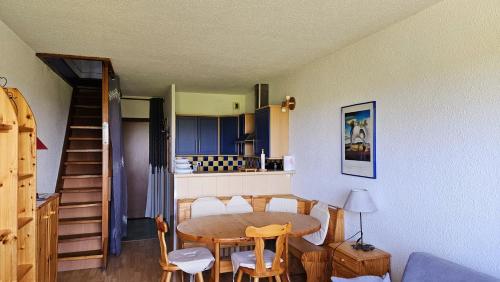 莱鲁斯Appartement Les rousses, Jura的厨房以及带桌椅的用餐室。