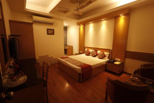 新德里Hotel Clark Height @New Delhi的一间卧室配有一张床和一台电视