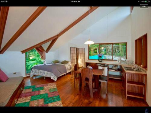 蒙泰韦尔德哥斯达黎加The Cloud Forest Magical Villa的一间卧室配有一张床,厨房配有桌子