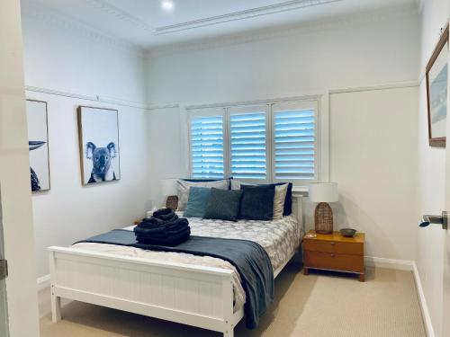 悉尼Family Getaway to Manly Beach plus free onsite parking, stroll to beach, cafes的白色卧室配有蓝色枕头的床