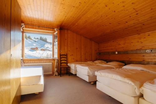 雷克罗塞Camp Suisse @ The Télécabine的带四张床和窗户的客房