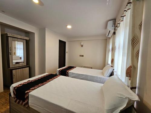 巴克塔普尔Hotel Durbar Side的酒店客房设有两张床和窗户。