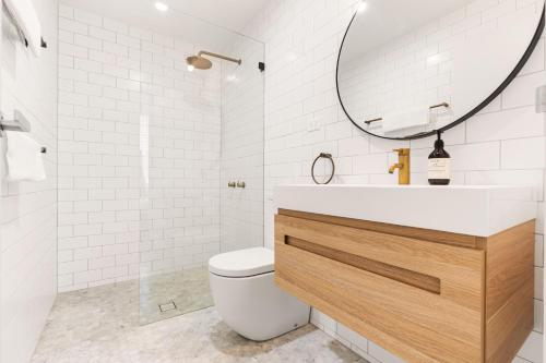 悉尼Bondi Oasis: 2BR + Balcony Bondi Beach的一间带卫生间、水槽和镜子的浴室
