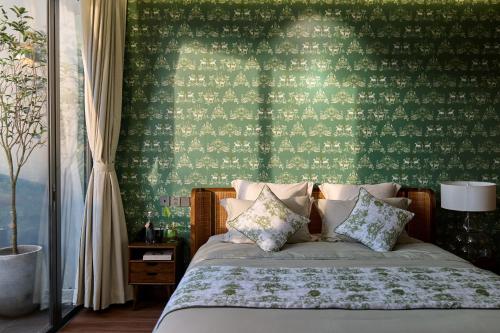 邦美蜀The Coffee City - Healing & Retreats的一间卧室配有一张带绿色墙壁的床
