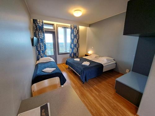 拉普阿辛普森库拉斯公寓式酒店的小房间设有两张床和窗户