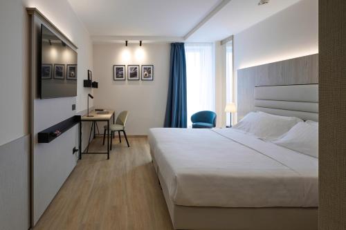 摩德纳RMH Modena Raffaello的配有一张床和一张书桌的酒店客房