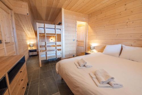 于埃Beau chalet GUSTAVE 4 chambres 50m piste Huez Express的小木屋内一间卧室,配有一张床