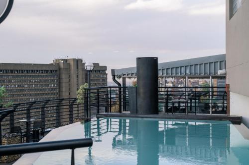 约翰内斯堡ANEW Hotel Parktonian Johannesburg的建筑物屋顶上的游泳池