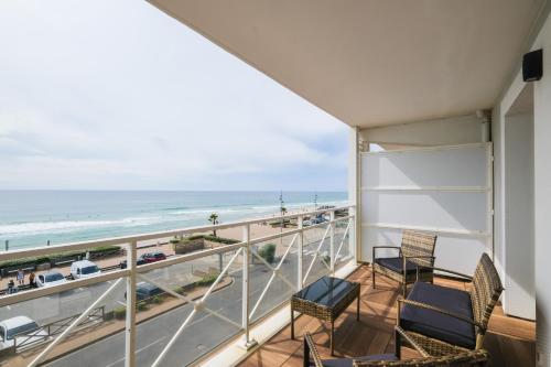 拉卡诺奥肯Appartement - vue exceptionnelle的一个带椅子的阳台,享有海滩美景