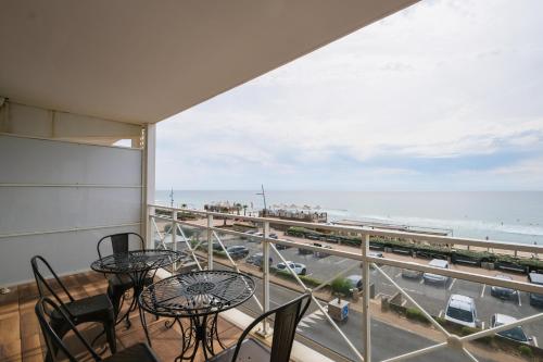 拉卡诺奥肯Appartement - vue exceptionnelle的阳台配有桌椅,享有海景。