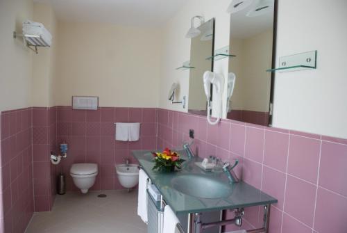 庞特卡格纳诺拉伊斯拉度假酒店的粉红色的浴室设有水槽和卫生间