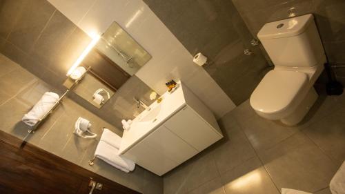 卡萨布兰卡Fourteen Hotel Ain Sebaa的浴室设有卫生间和带镜子的盥洗盆