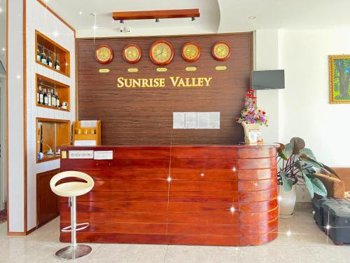 大叻Sunrise Valley Dalat Hotel的墙上有日出山谷标志的餐厅