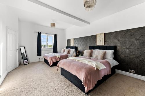 切尔滕纳姆Stunning 4 Bed House - Sleeps 12的卧室设有2张床和白色的墙壁。