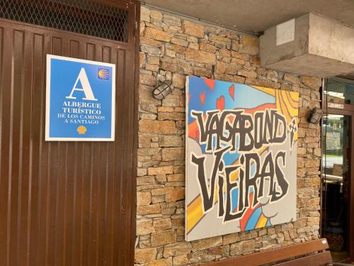 拉波尔特拉德瓦尔卡Vagabond Vieiras Beds & Dinner Albergue的石墙上贴有两张海报的建筑
