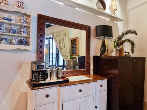 金马仑高原Clocktower 2 Homestay 2-7 pax at Brinchang, Cameron Highlands的客房设有镜子和带咖啡壶的柜台。