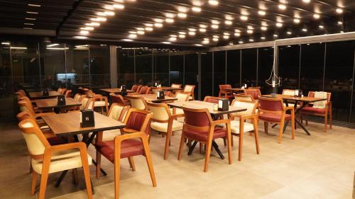 伊斯坦布尔Amber Palace Hotel的餐厅设有木桌和椅子及灯