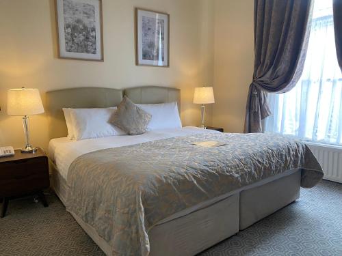 都柏林菲兹威廉姆联排别墅酒店的一间卧室配有一张带两盏灯的床和一扇窗户。