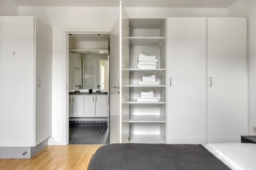 哥本哈根Amazing Two Bedroom Flat in Urban Area的卧室拥有白色的墙壁和白色的架子
