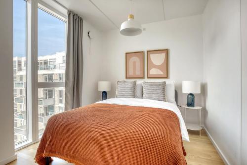 哥本哈根Amazing Two Bedroom Flat in Urban Area的一间卧室设有一张床和一个大窗户