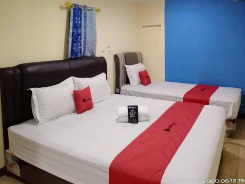 棉兰RedDoorz At Jalan Japaris Medan的两张带红色和白色枕头的床