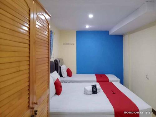 棉兰RedDoorz At Jalan Japaris Medan的蓝色墙壁客房的两张床