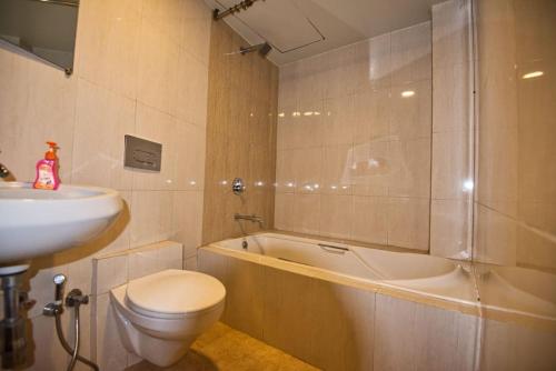 VasindSrushti Farms Resort的浴室配有盥洗盆、卫生间和浴缸。