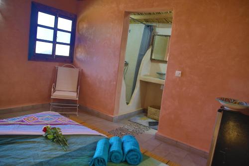 马拉喀什Dar Koujane的卧室配有一张带蓝色鞋的床,位于地板上