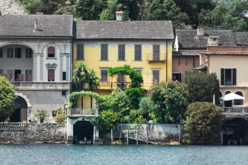 奥尔塔圣朱利奥La Casa dell'Isola的水体上的一个黄色房子