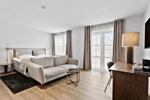 腓特烈港赫尔曼班戈贝斯特韦斯特酒店的一间卧室配有一张床、一张沙发和一张桌子