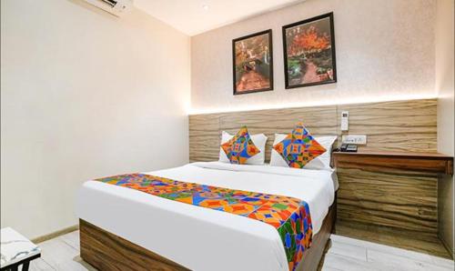 孟买FabExpress The DR Residency的配有一张床和一张书桌的酒店客房